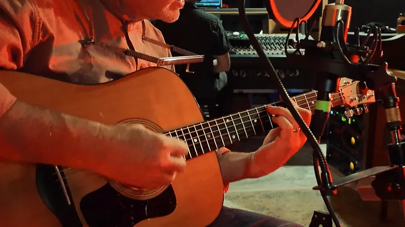 Close view of fingerpicking on an acoustic guitar